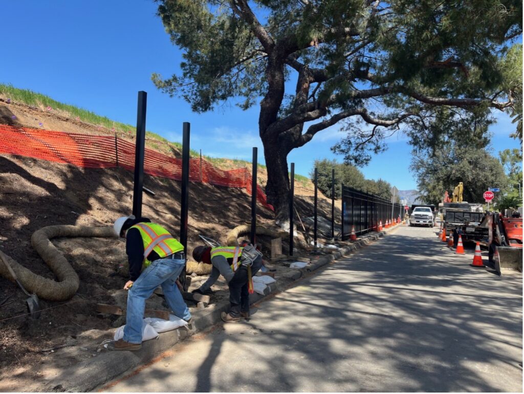 Workers installing steel polls along the curve