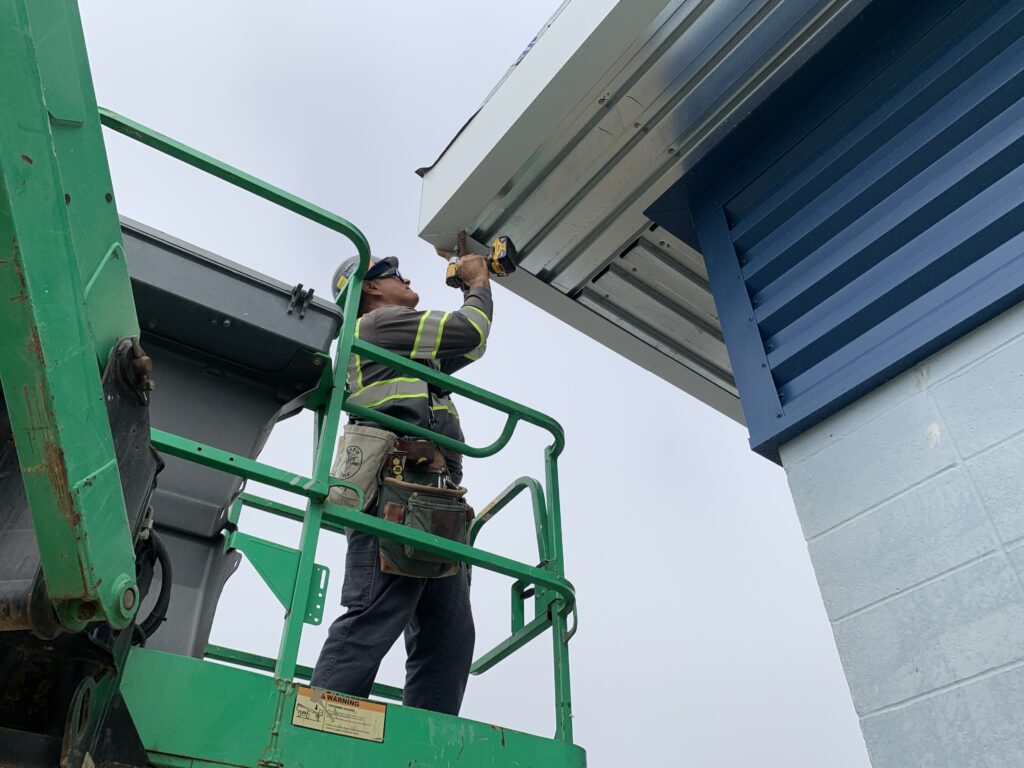 Man working on the finishing touch of the pump station roof