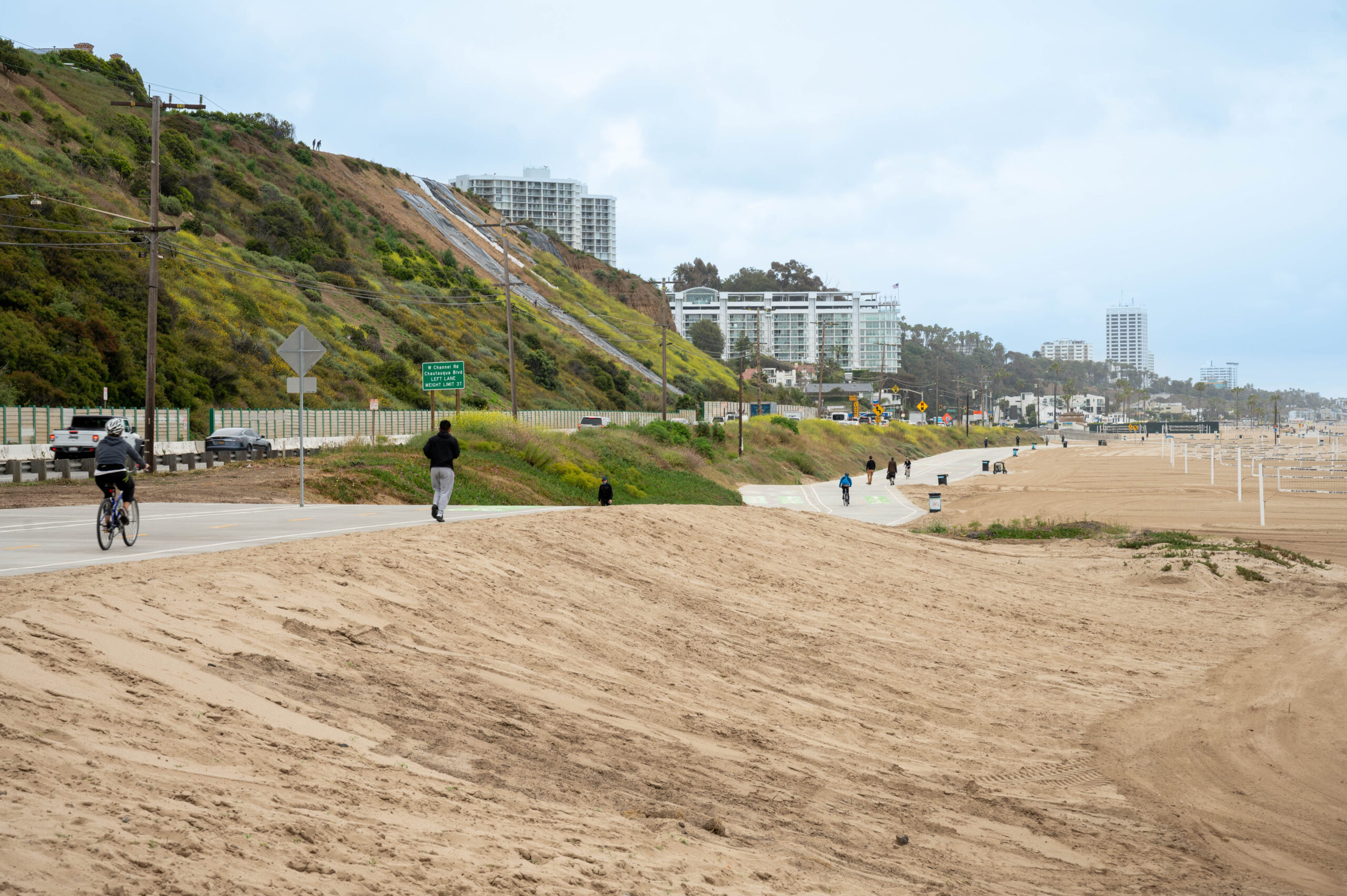 View of a bike trail next to a road and sandy area