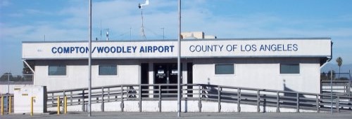 Front view of the Compton/Woodley Airport building in Los Angeles County, California. The single-story structure has a flat roof and a ramp leading to the entrance.